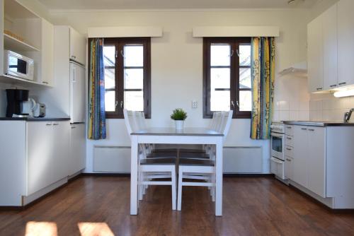 a kitchen with a table and chairs in a room at Visulahti Cottages in Mikkeli