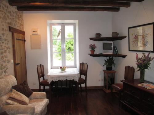 un salon avec une table et une fenêtre dans l'établissement Chez Tartaud, à Lathus St Remy