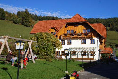 a man is standing in front of a house at Alpengasthof Moser in Karchau