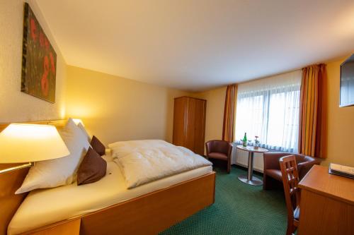 ein Hotelzimmer mit einem Bett und einem Schreibtisch in der Unterkunft Hotel Burgfrieden in Beilstein