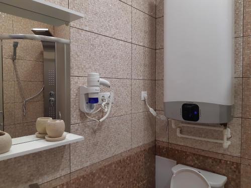 a bathroom with a toilet and a dispenser on a wall at Apartment in ZHK Sputnik in Dombay