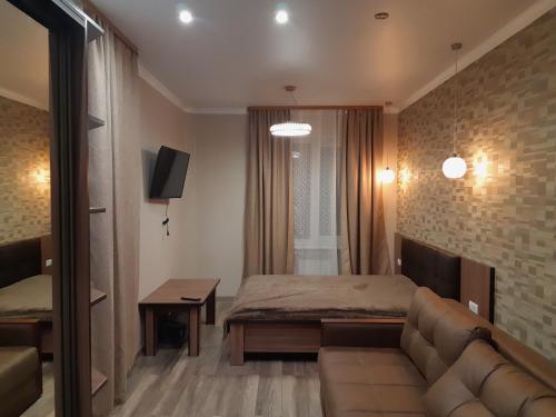 a room with a couch and a bed and a tv at Apartment in ZHK Sputnik in Dombay