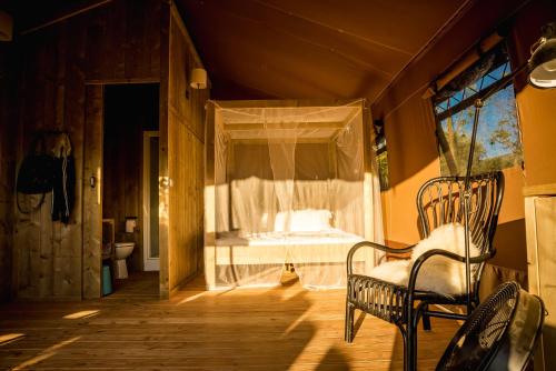 ベヴァーニャにあるLodge Holidays - Pian di Boccioのベッドルーム1室(窓、ベッド1台、椅子付)