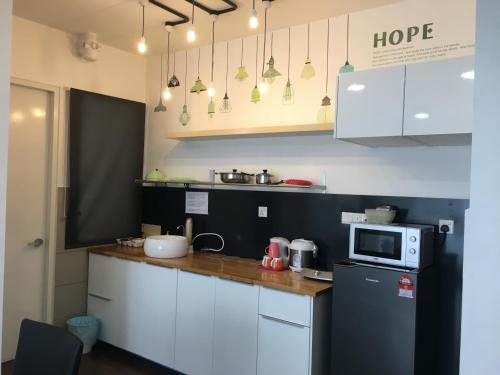 a small kitchen with a refrigerator and a microwave at Woodsbury Suites 7722 Butterworth Penang in Butterworth