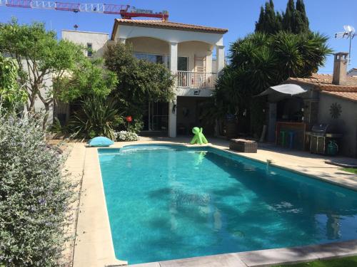 a swimming pool in front of a house at Villa Kalimera in Sérignan