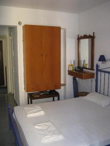 sypialnia z łóżkiem i drewnianą szafką w obiekcie EL GRECO w mieście Rodos