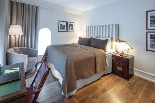 a hotel room with a bed and a chair at Kokkedal Slot Copenhagen in Hørsholm