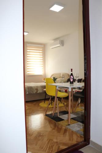 a dining room with a table and yellow chairs at Apartman Studio 2 in Brčko