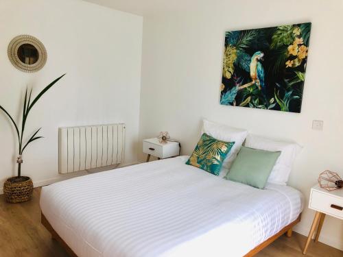 - une chambre avec un lit blanc et une peinture murale dans l'établissement VILLA BIRDS, à Boran-sur-Oise