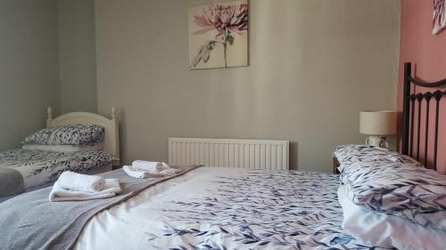 a bedroom with two twin beds with towels on them at The Bugle Inn in St Austell