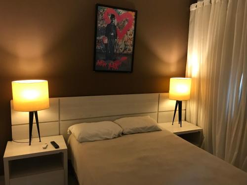 a bedroom with a bed with two lamps on it at Aldeia das Águas Barrakana flats in Nossa Senhora das Dores