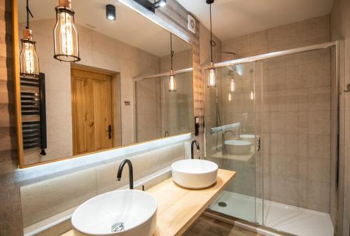 a bathroom with two sinks and a mirror at Willa Pokusa in Szczawnica