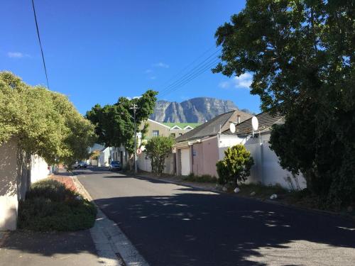 a street with houses and a mountain in the background at Delightful Surrey Street in Cape Town