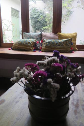 a vase of flowers sitting on a table in front of a window at Casa Elizabeth in Quetzaltenango