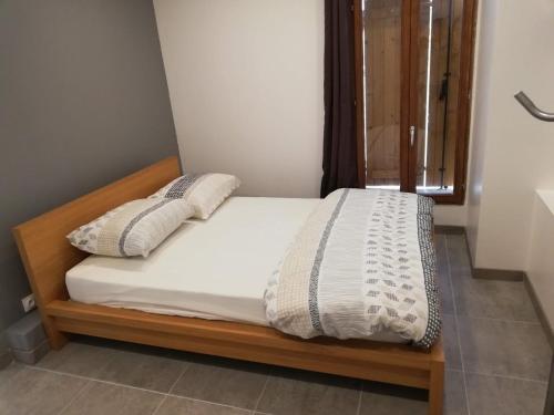 - un lit avec des draps et des oreillers blancs dans l'établissement Maison Duplex & Appartement sur cour, à La Ferté-Gaucher