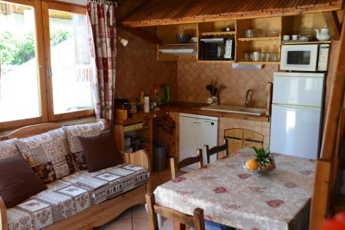 une petite cuisine avec une table et une cuisine avec une table et un canapé dans l'établissement Partie de chalet, à Saint-Chaffrey