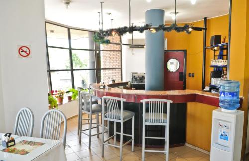 a kitchen with a bar with chairs around it at Hotel Tres Cruces in Montevideo