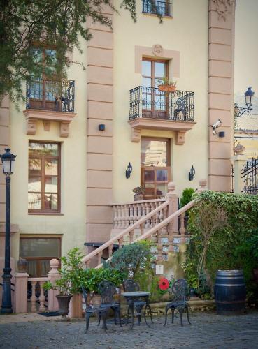 a building with a staircase and chairs in front of it at Palacio Azcárate Hotel in Ezcaray