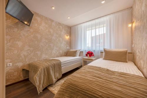 a bedroom with two beds and a tv on the wall at Kesminta Šalčininkai in Šalčininkai