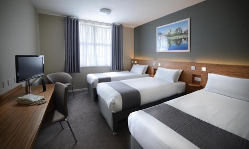 a hotel room with two beds and a flat screen tv at Travelodge Plus Galway in Galway