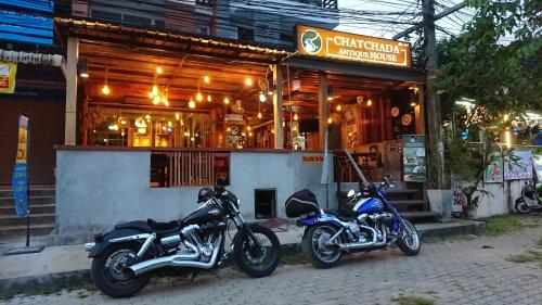 two motorcycles parked in front of a building at Chatchada House in Ao Nang Beach