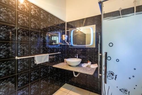 a bathroom with a sink and a mirror at La Modestie Guest House in Grand'Anse Praslin