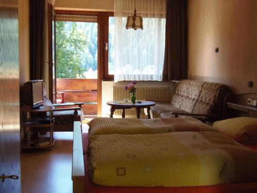 1 dormitorio con cama, sofá y ventana en Gasthof Erlenhof, en Alpirsbach