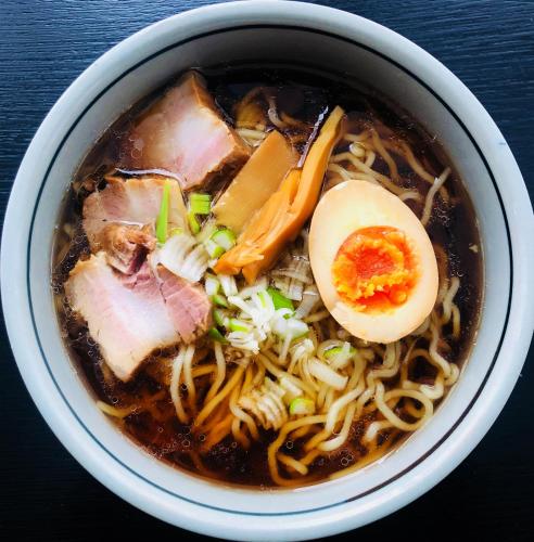 a bowl of soup with a egg on top at La Vista Hotel Tsugaike - Stay on the Slopes in Otari