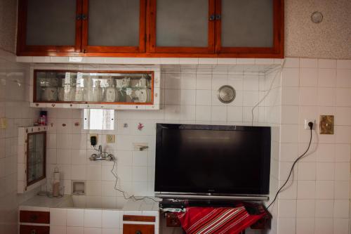 a flat screen tv on the wall of a kitchen at Velkovski Guest House in Hisarya