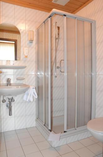ein Bad mit einer Dusche und einem Waschbecken in der Unterkunft Gasthof Löwen Worb bei Bern in Worb