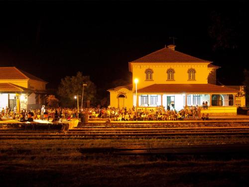 a group of people sitting outside a building at night at Train Spot Guesthouse in Marvão