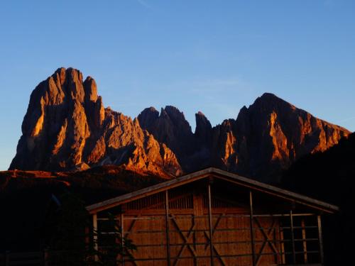 a cabin with mountains in the background at Albergo Somont in Ortisei