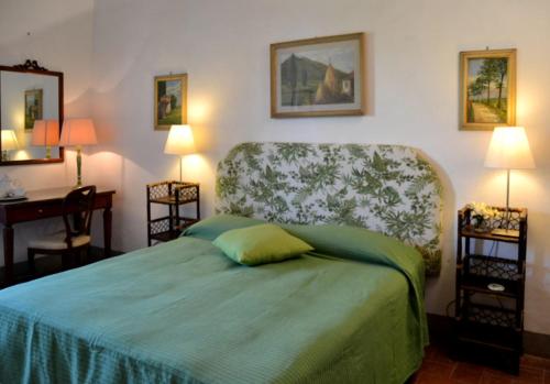 a bedroom with a green bed and a chair at Locanda di Praticino in Rufina