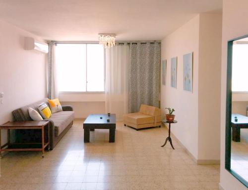 uma sala de estar com um sofá e uma mesa em 1Bdrm APT With Panoramic View of Sea and Mountains em Tiberias