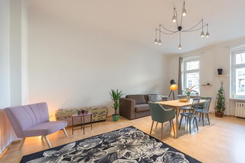ein Wohnzimmer mit einem Tisch und Stühlen in der Unterkunft Design Apartments - "Am Schloss" in Potsdam