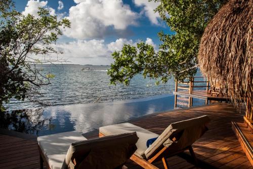 a wooden bench sitting on top of a beach next to a body of water at Hotel Las Islas in Barú