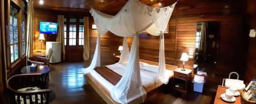 a bedroom with a bed with a white canopy at Highland Resort & Nature Tours in Tomohon
