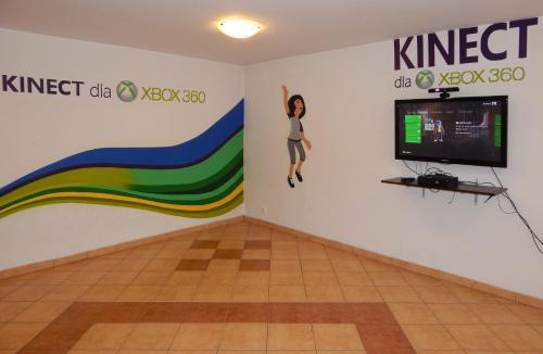 a room with a tv and a mural on the wall at Hotel ROK in Kraków