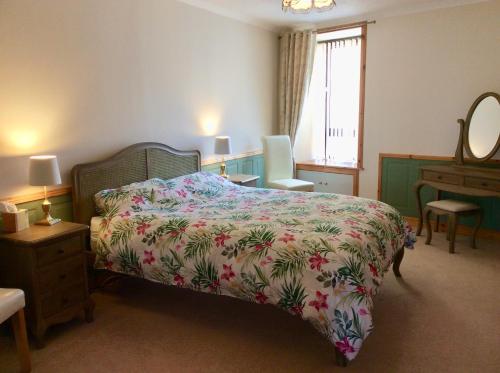 a bedroom with a bed and a dresser and a mirror at BORD DE L’EAU APARTMENT in Wick