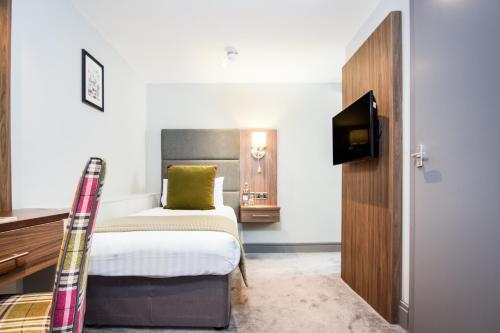 a hotel room with a bed and a television at The Yorkshire in Harrogate