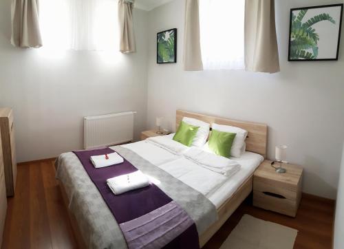 a bedroom with a bed with two towels on it at Gardenia Apartman in Esztergom