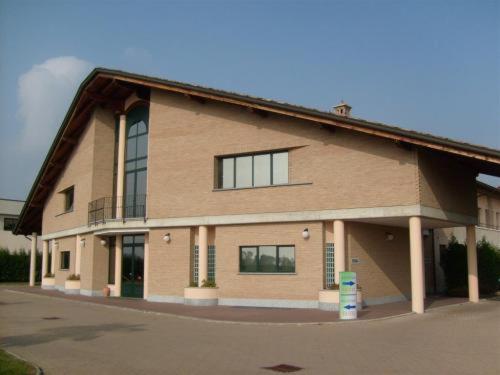 - un grand bâtiment en briques avec des fenêtres donnant sur une rue dans l'établissement Hotel - Motel Flower, à Gropello Cairoli