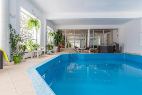a large swimming pool in a room with plants at Rezydencja Marjo z basenem in Kościelisko