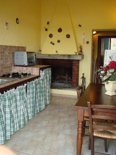 a kitchen with a fireplace and a table and a table sidx sidx at Poggio San Giacomo in Baschi
