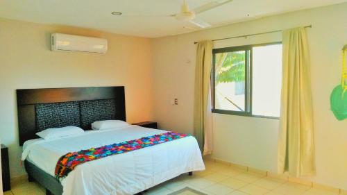 Säng eller sängar i ett rum på Hotel Kinich Ahau