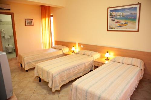 a hotel room with three beds and a bathroom at Caffè Nuovo 2 Holiday Rooms in Trappitello
