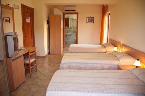 a hotel room with four beds and a television at Caffè Nuovo 2 Holiday Rooms in Trappitello