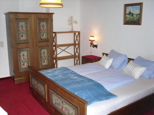 een slaapkamer met een bed en een houten kast bij Vorderwiesgut in Altenmarkt im Pongau