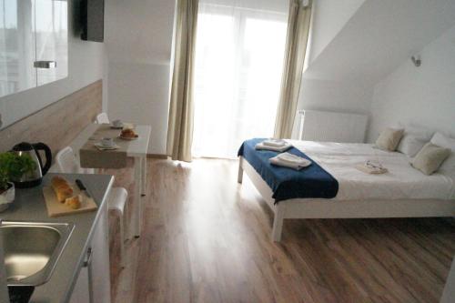 a small room with a bed and a sink in it at Willa Wena in Ustka