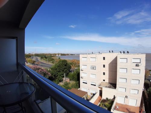 balcón con vistas a un edificio con pájaros en el techo en Eugenio Araus Apartamento 504 en Colonia del Sacramento